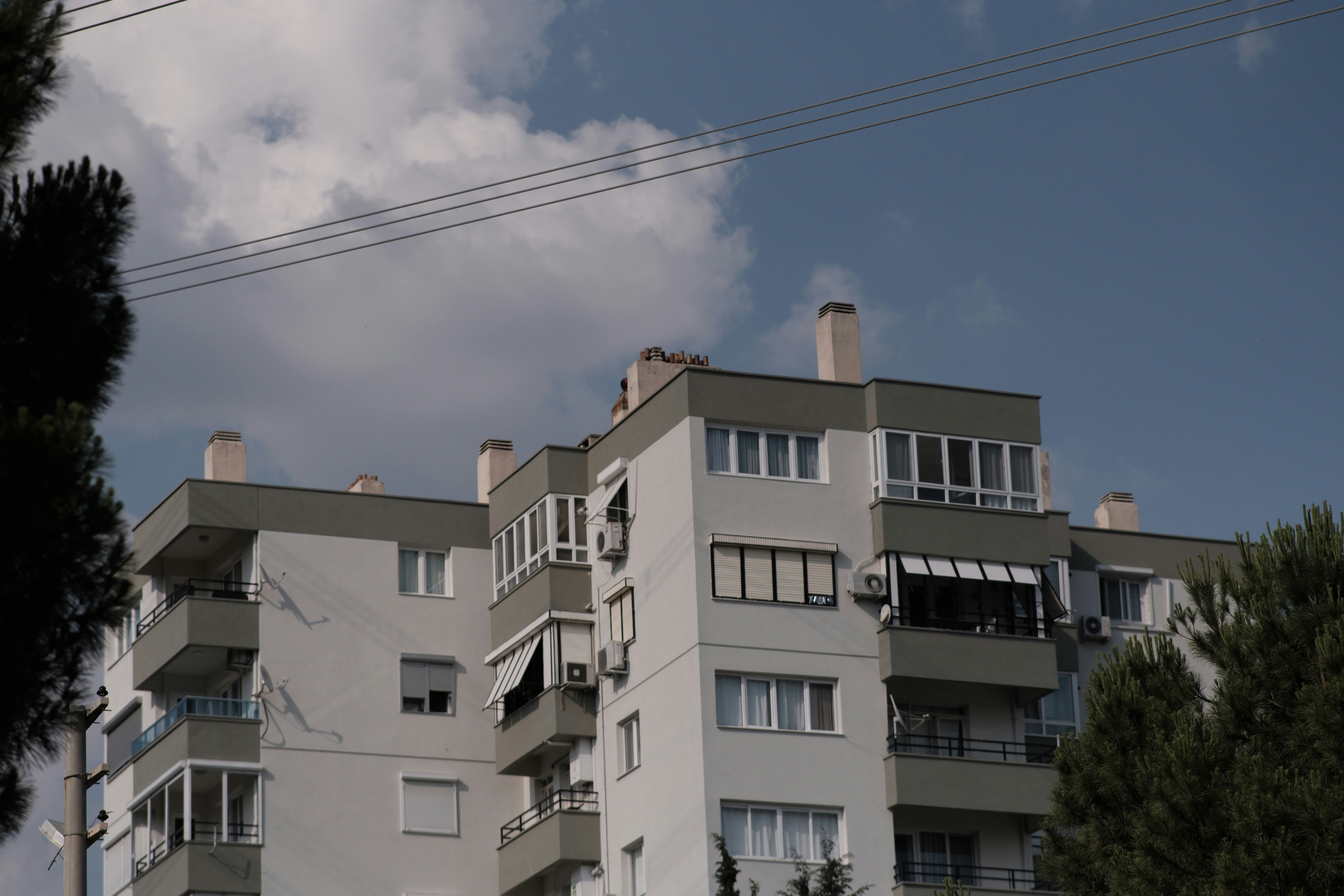 Modern apartment building with balconies against a cloudy blue sky
